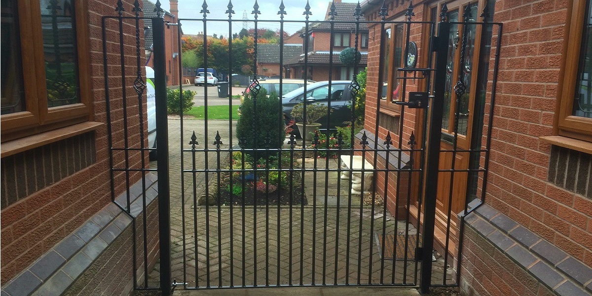 Bespoke metal side garden gate fitted between a house and garage