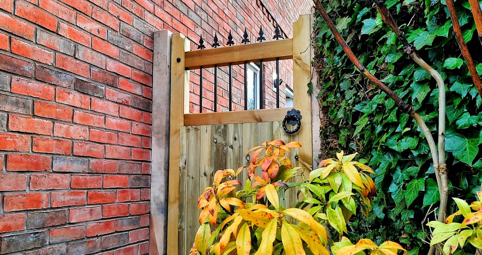 wooden side gate with metal infill bars and finials