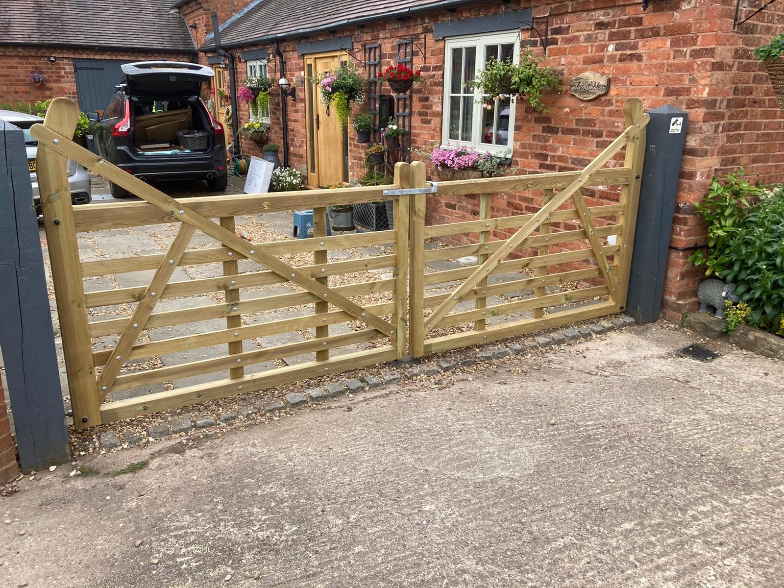 Pressure treated timber field gates securing residential driveway entrance