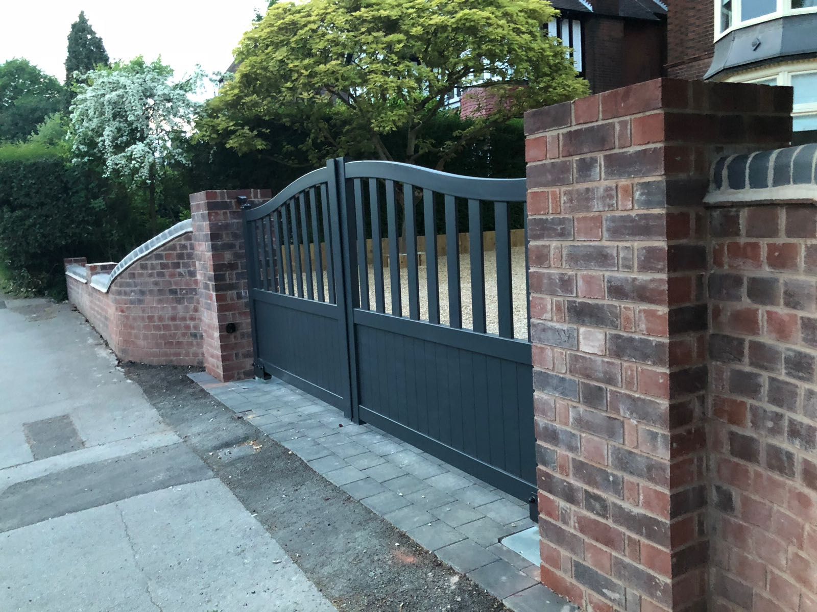 Arched open pale double aluminium gates fitted to brick pillars