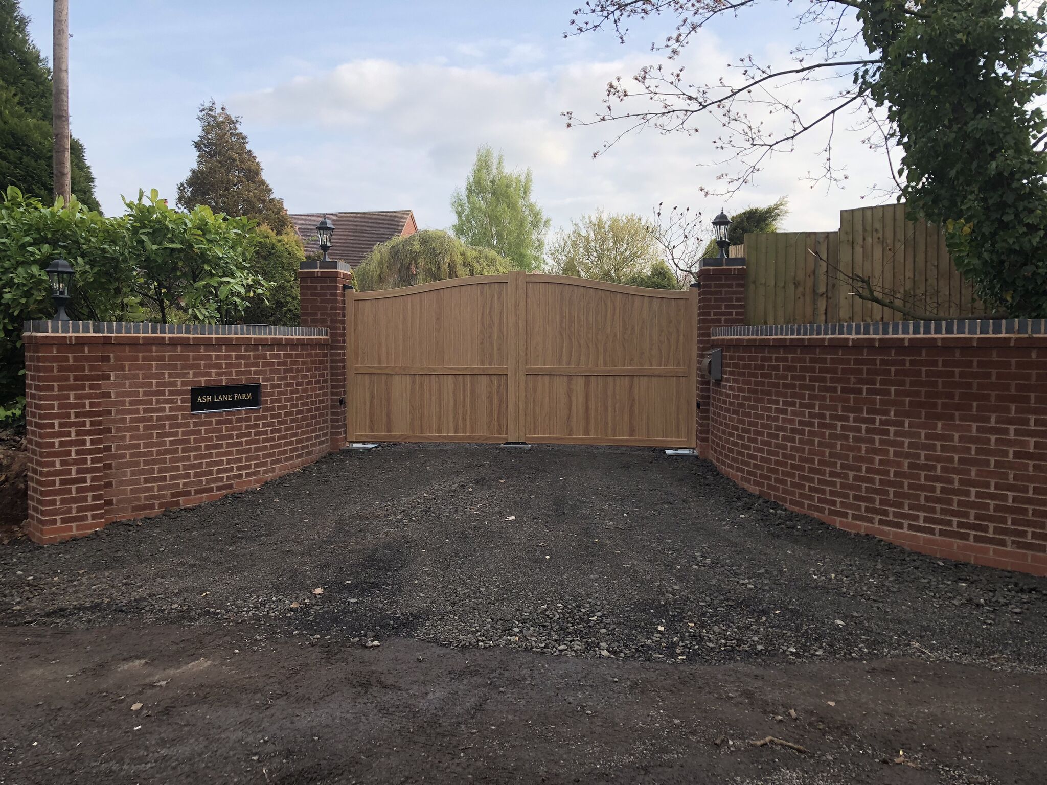 Modern aluminium driveway gates painted with a woodgrain finish