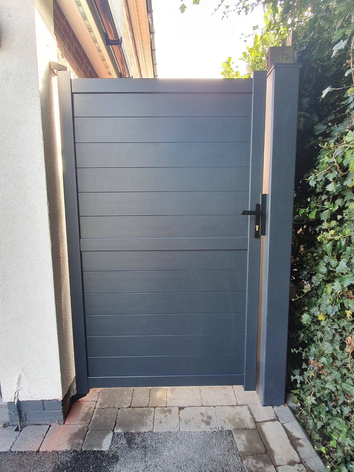 Anthracite grey modern aluminium pedestrian gates fitted to side access point to garden