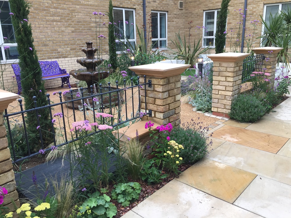 Ball top wrought iron style metal railings fitted between brickwork pillars