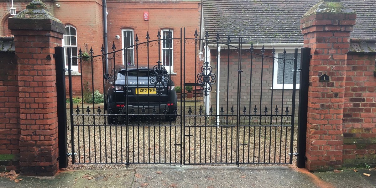 Royal premier bi folding driveway gates mounted to large brick pillars