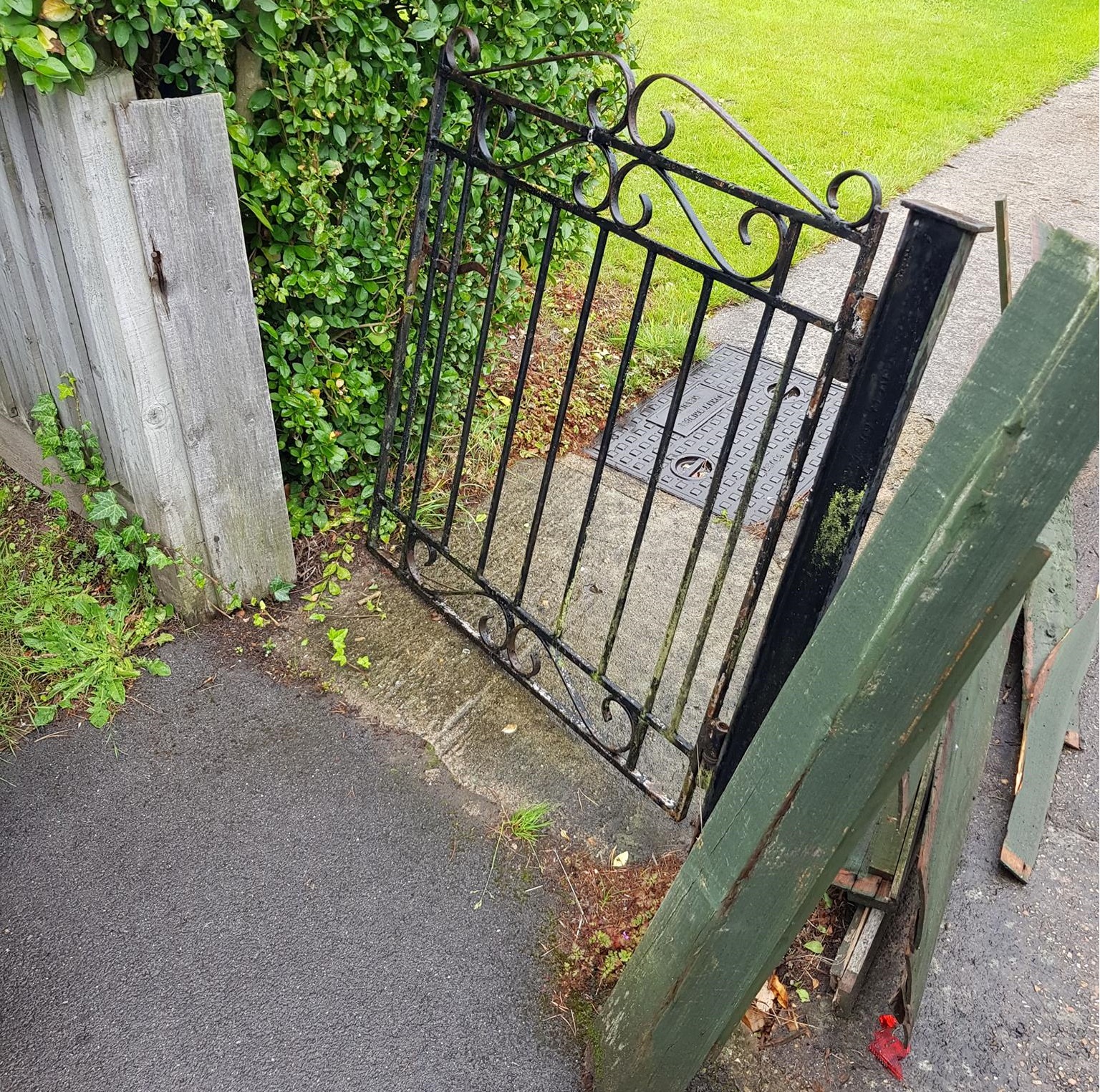 damaged metal gate with post falling over