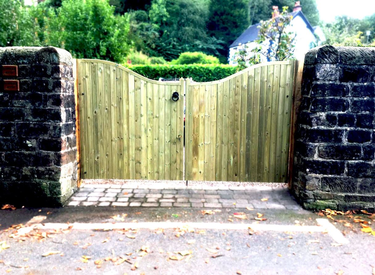 Curved wooden driveway gates in a traditional style