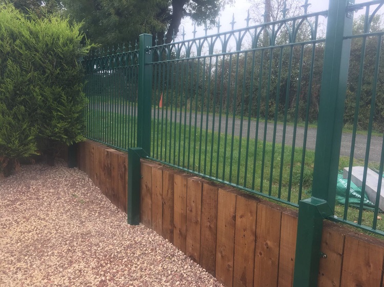 Green powder coated iron fence panels fitted across the front garden