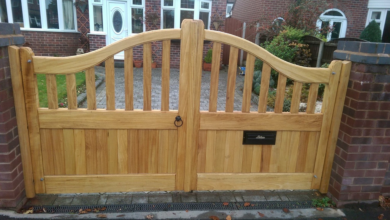 Idigbo swan neck double driveway gates with spindles and vertical boards