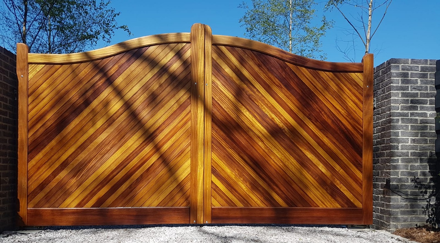 Iroko arched top driveway gates with diagonal infill boards