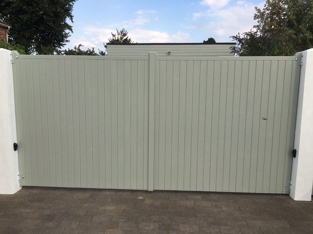 Norfolk wooden estate gates painted green mounted to white masonry pillars