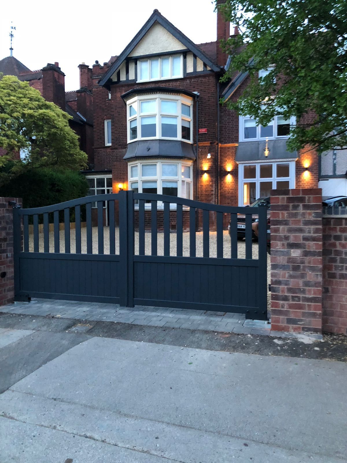 Open infill aluminium driveway gates fitted to entrance of large Victorian property