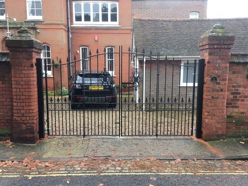 Wrought iron bi folding gates fitted to wall mounted posts