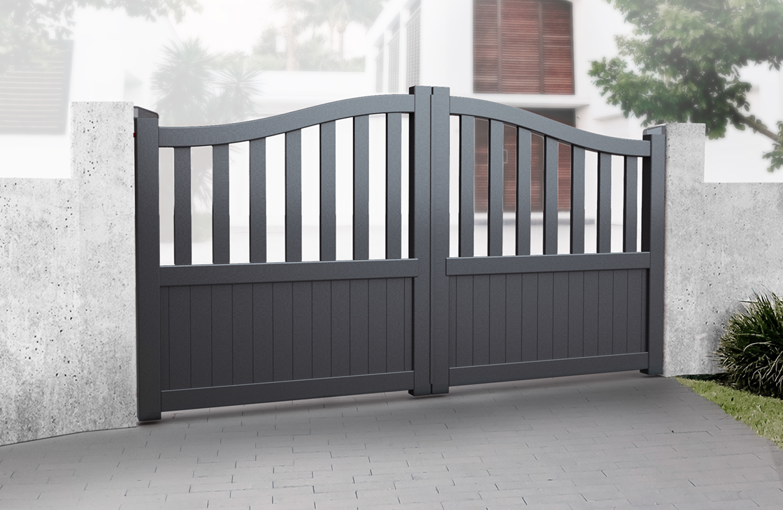 Vertical boarded aluminium driveway gates with an arch top and long open pales in anthracite grey