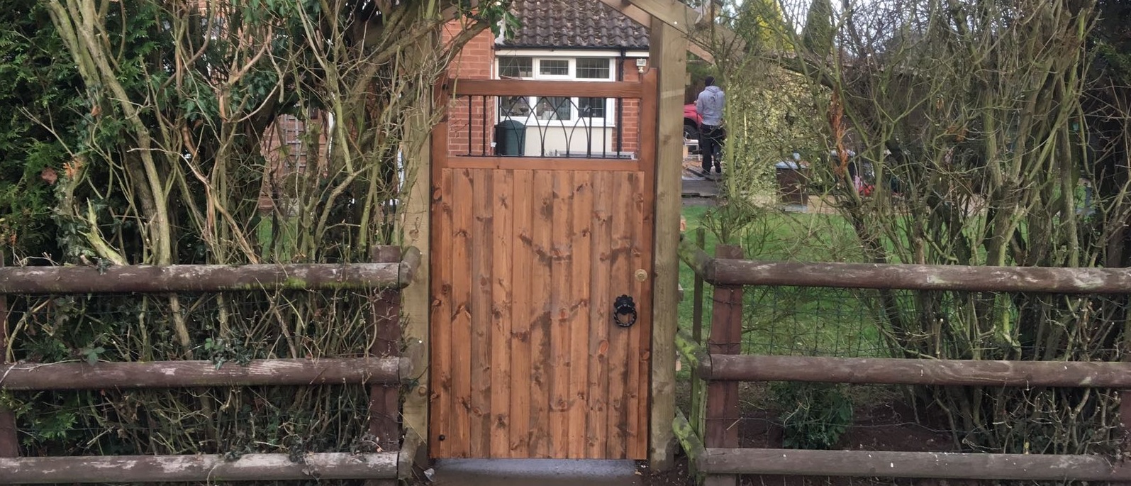 Windsor wooden side gate with a medium stain similar to walnut