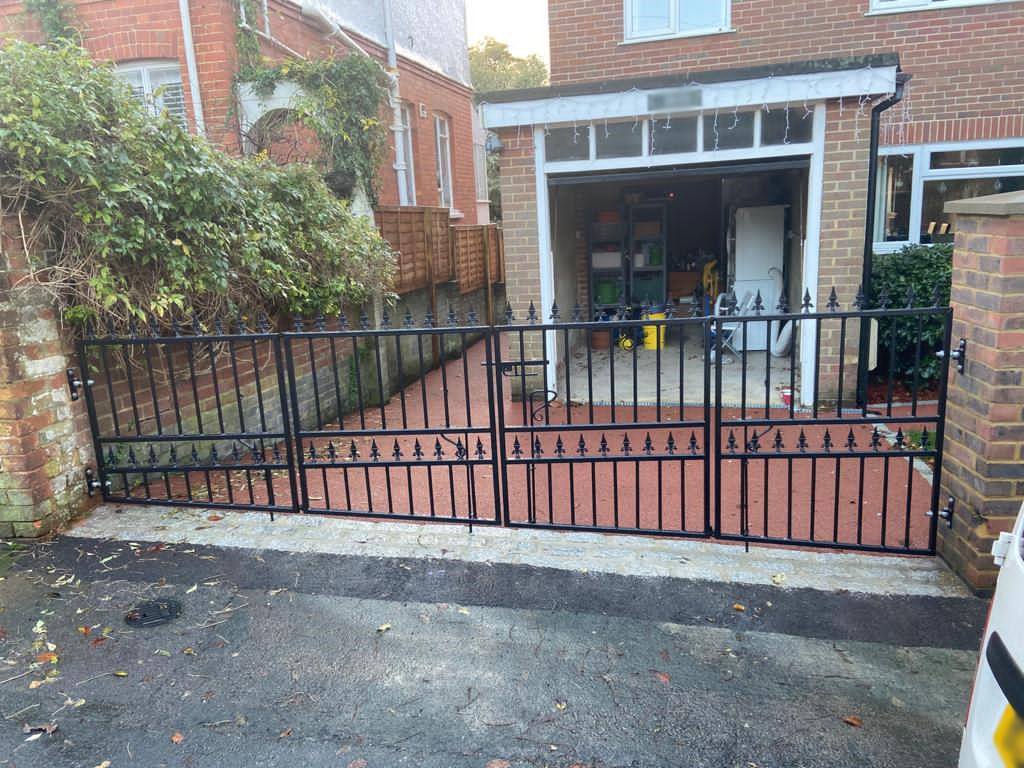 Driveway gate with a sloping bottom rail